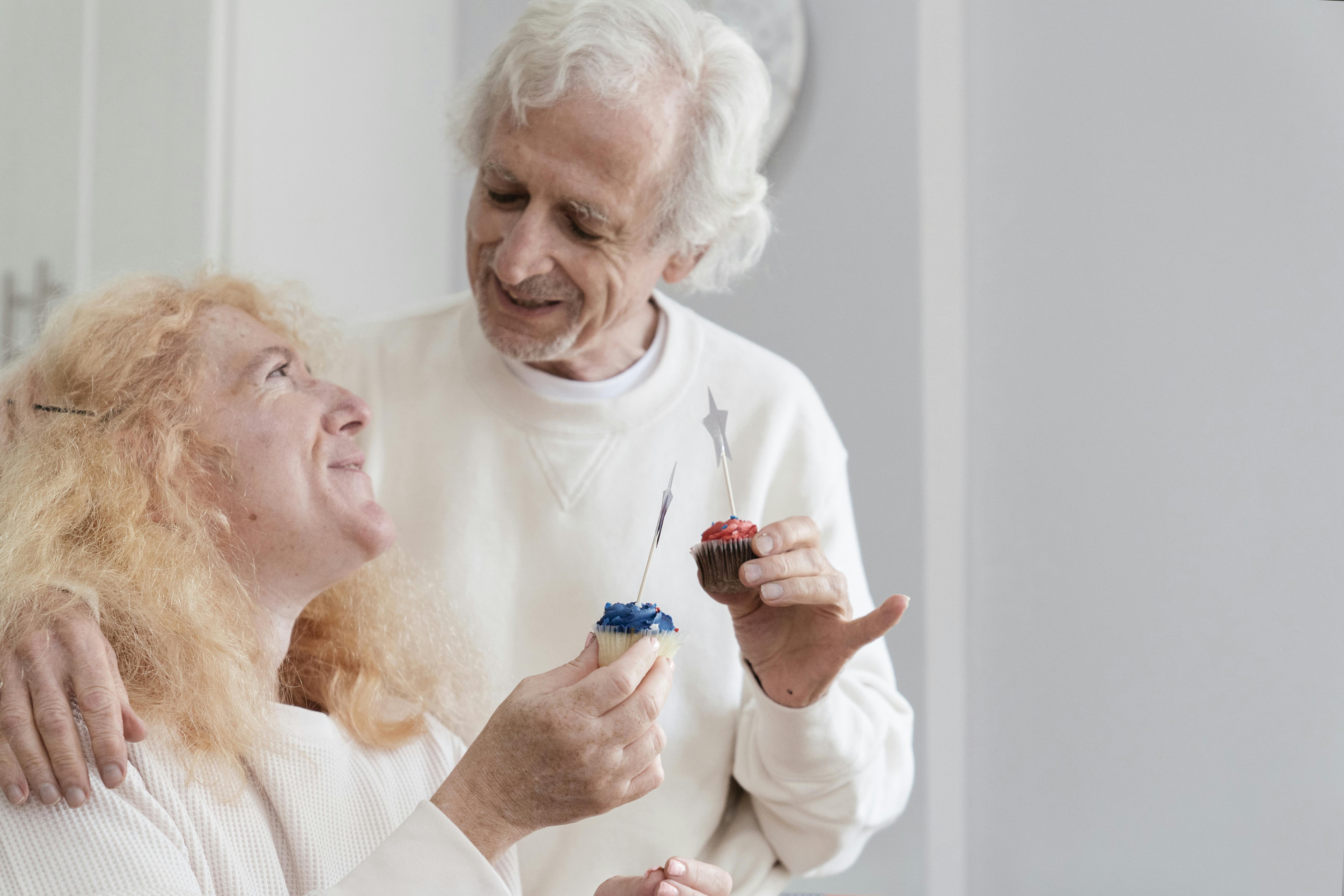 elderly couple holding mini cupcakes