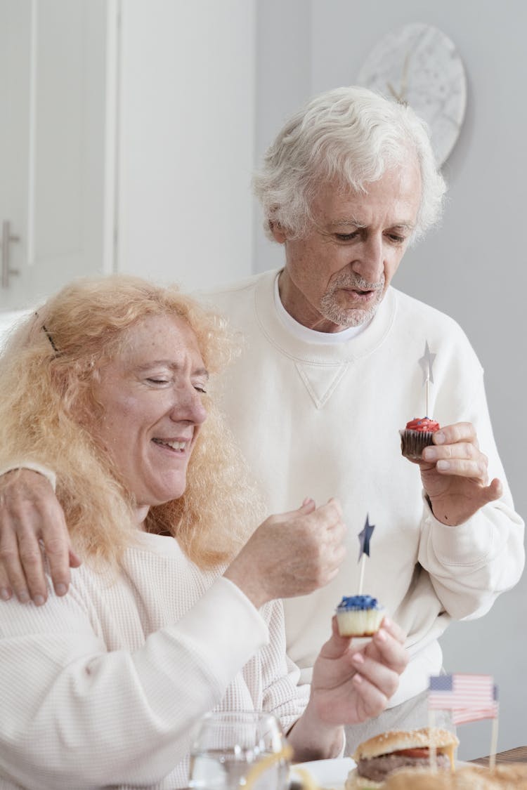 An Elderly Couple Celebrating The Holiday With Cupcakes