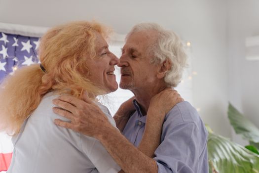 An elderly LGBT couple embracing lovingly indoors, radiating intimacy and warmth.