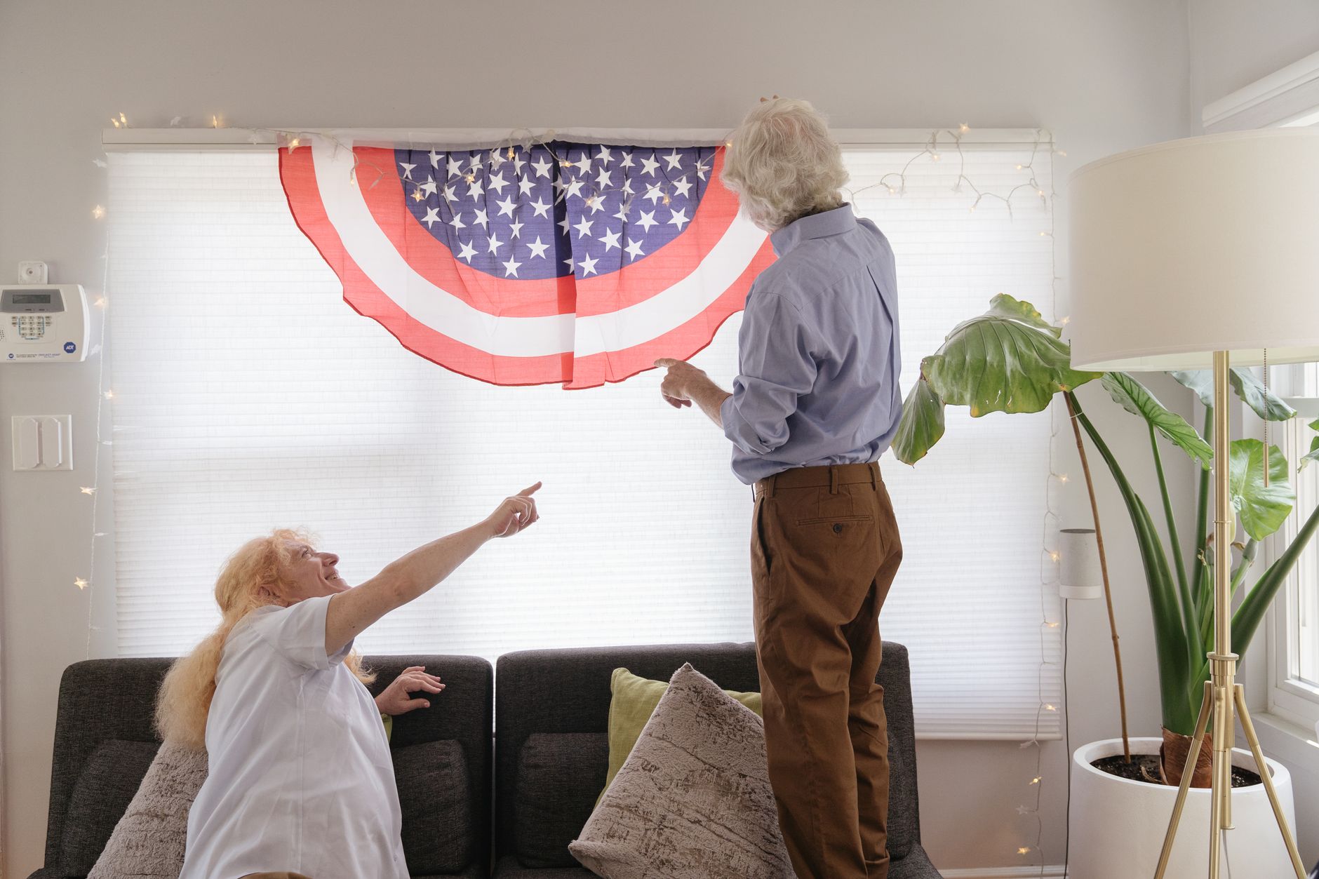 4th of july decorations for home Senior couple celebrates 4th of July with American flag decoration in cozy living room.