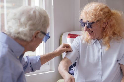 Free Joyful senior couple wearing star-shaped glasses indoors during a festive celebration. Stock Photo
