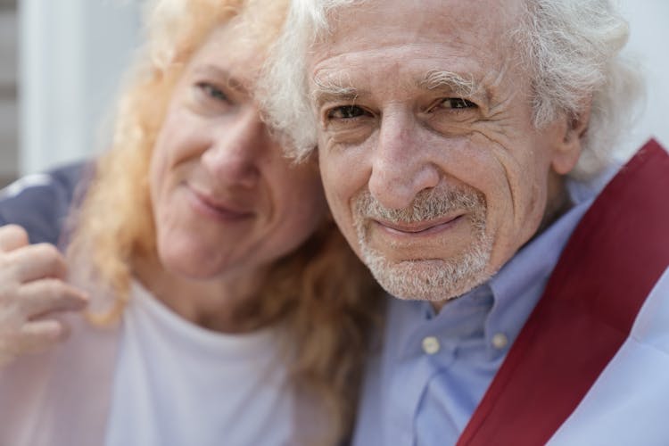 Close-up Of An Elderly Couple Draped With The American Flag