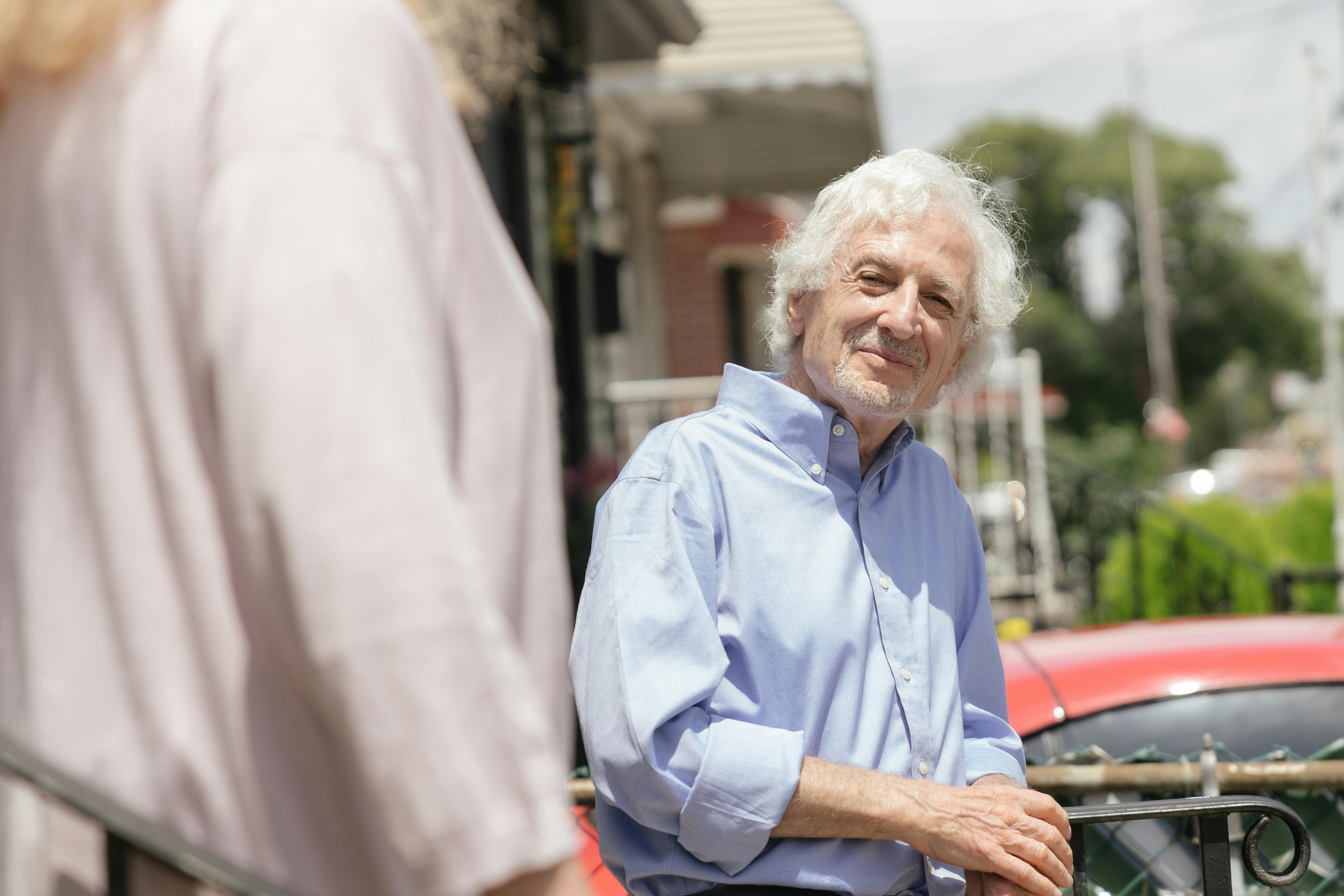 Smiling elderly man leaning on handrail