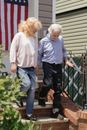 Woman Assisting an Elderly Man Going Down the Stairs