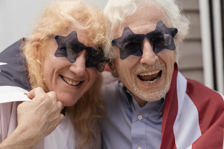 Happy Elderly Couple Wearing Star-shaped Sunglasses