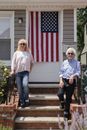 A Couple Standing on Concrete Stairs with an American Flag Hanging on Wall