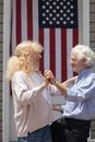 A Couple Dancing with an American Flag Hanging on Background