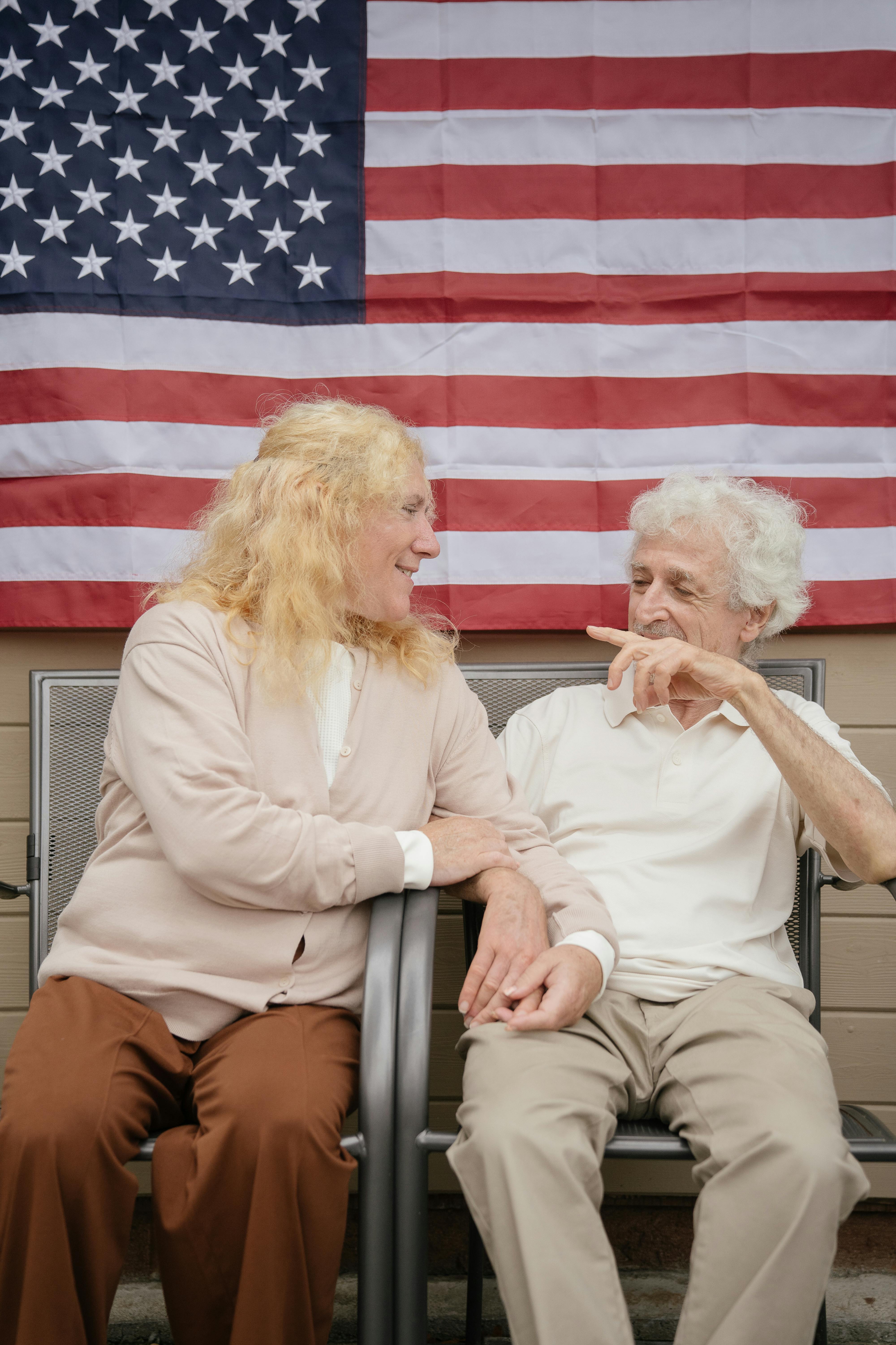 an elderly couple sitting on metal chairs