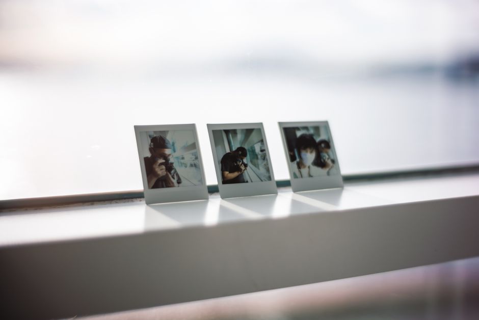 カジュアルな思い出を捉えた3枚のポラロイド写真が窓の縁に展示されています。
