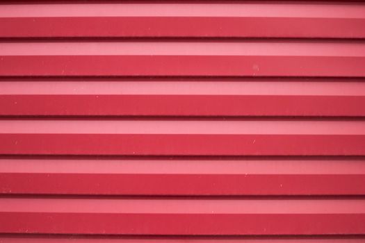 Close-up shot of a red corrugated metal surface providing a textured background.