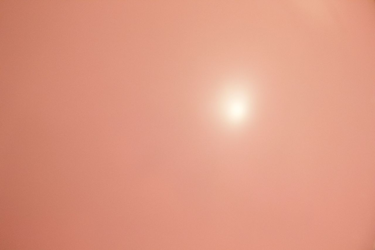 dreamy soft peach pink background with bright sun ideal for wallpapers