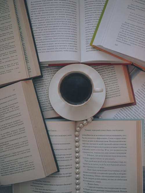 Overhead Shot of a Cup of Black Coffee Beside Books
