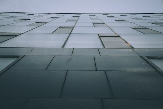 低角度视角下的现代建筑，带有玻璃窗和几何图案