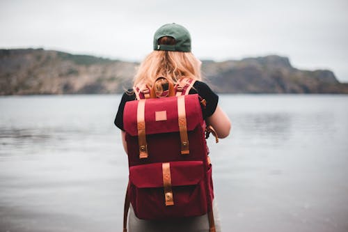 Selective Focus Photo of a Woman Wearing a Red Backpack