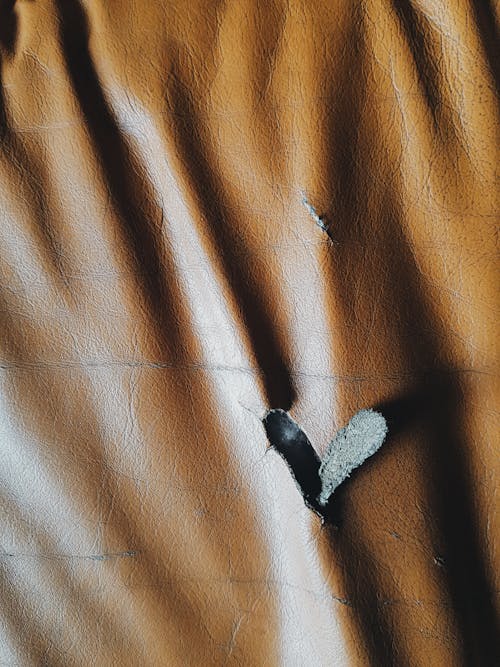 Free A Heart Shaped Hole on a Brown Leather Stock Photo