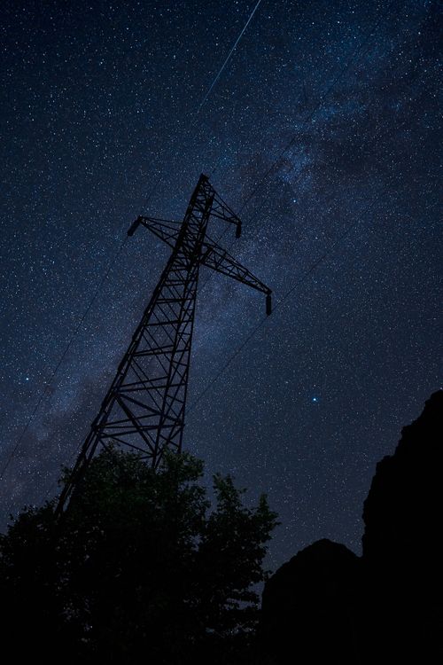 Free Dramatic starry night sky with Milky Way and silhouette of an electric tower. Stock Photo
