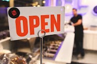 洛杉矶一家商店里，一个模糊的人影映衬着充满活力的营业标志