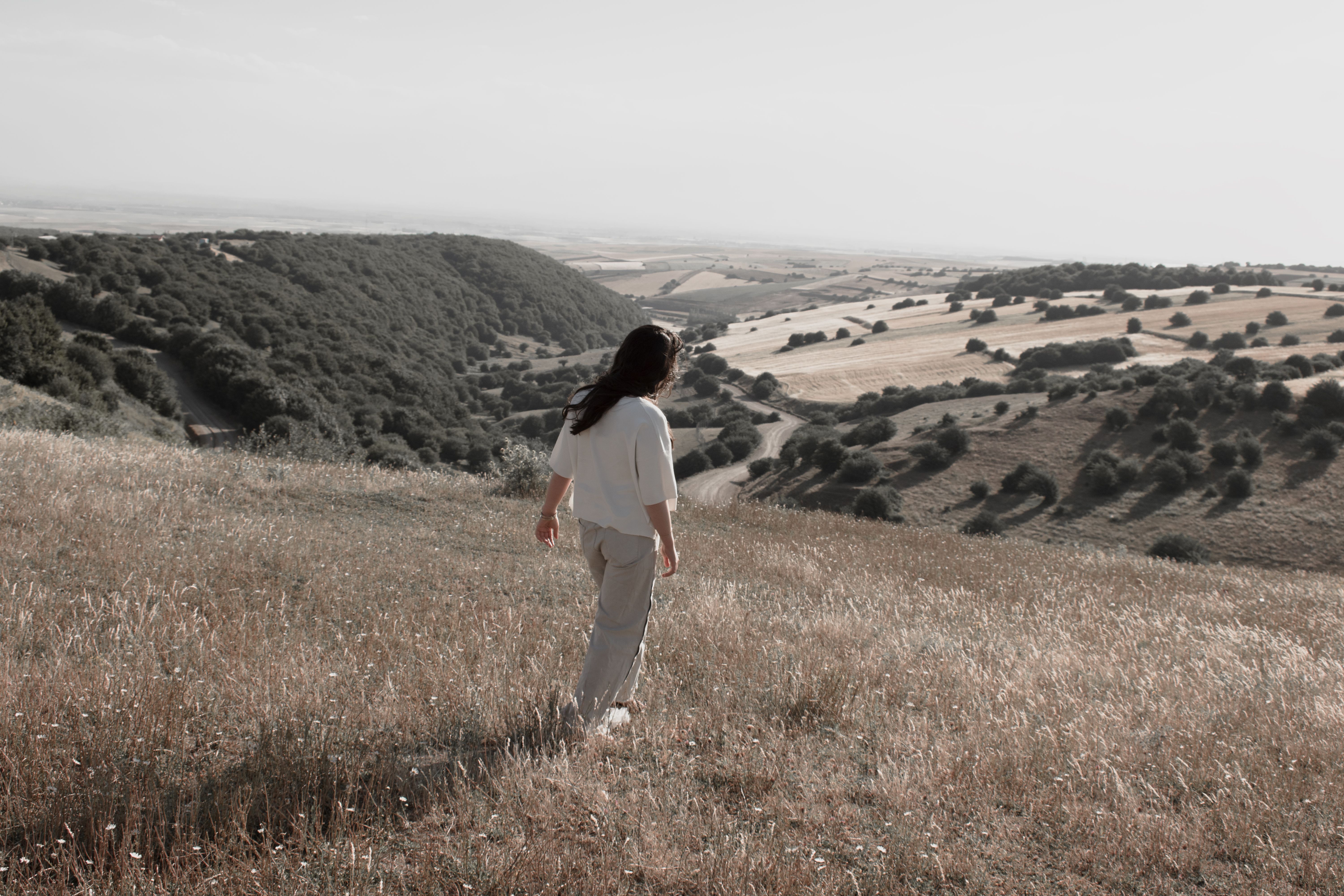 Woman in White Shirt Walking on Grass Field · Free Stock Photo