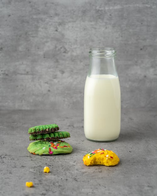 Close-Up Photo of a Jar of Milk Near Cookies