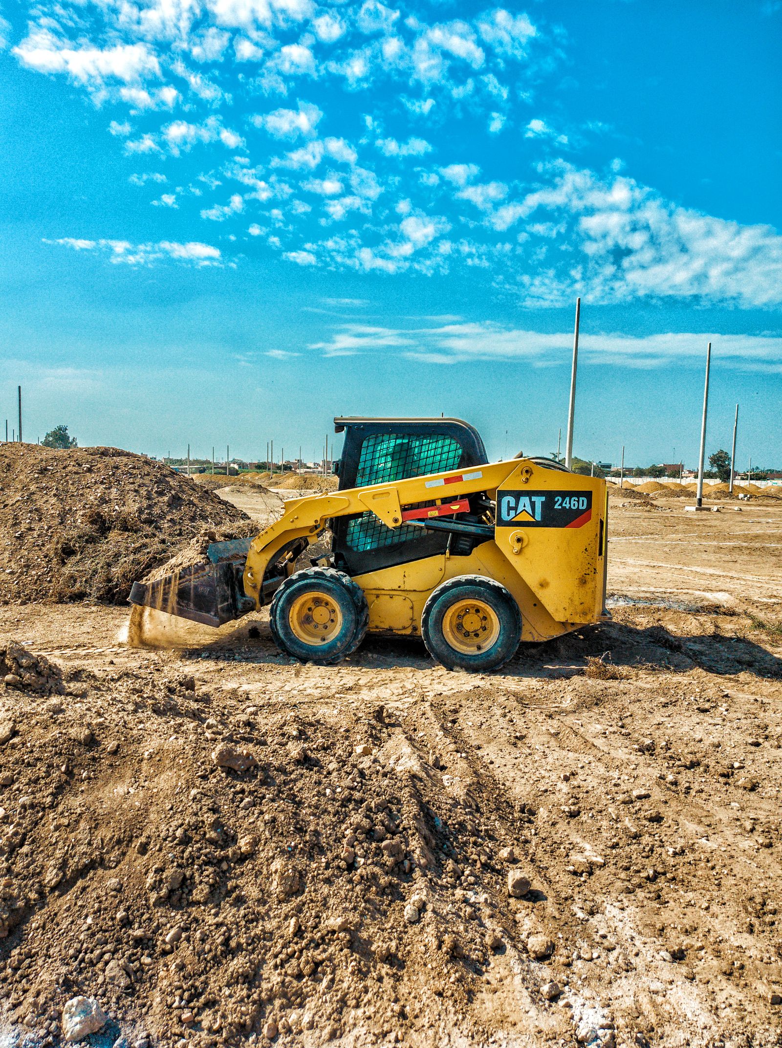 Skid steer loader grading dirt on a job site