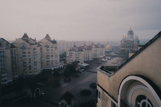 A high-angle view of a cityscape featuring unique architecture under an overcast sky.