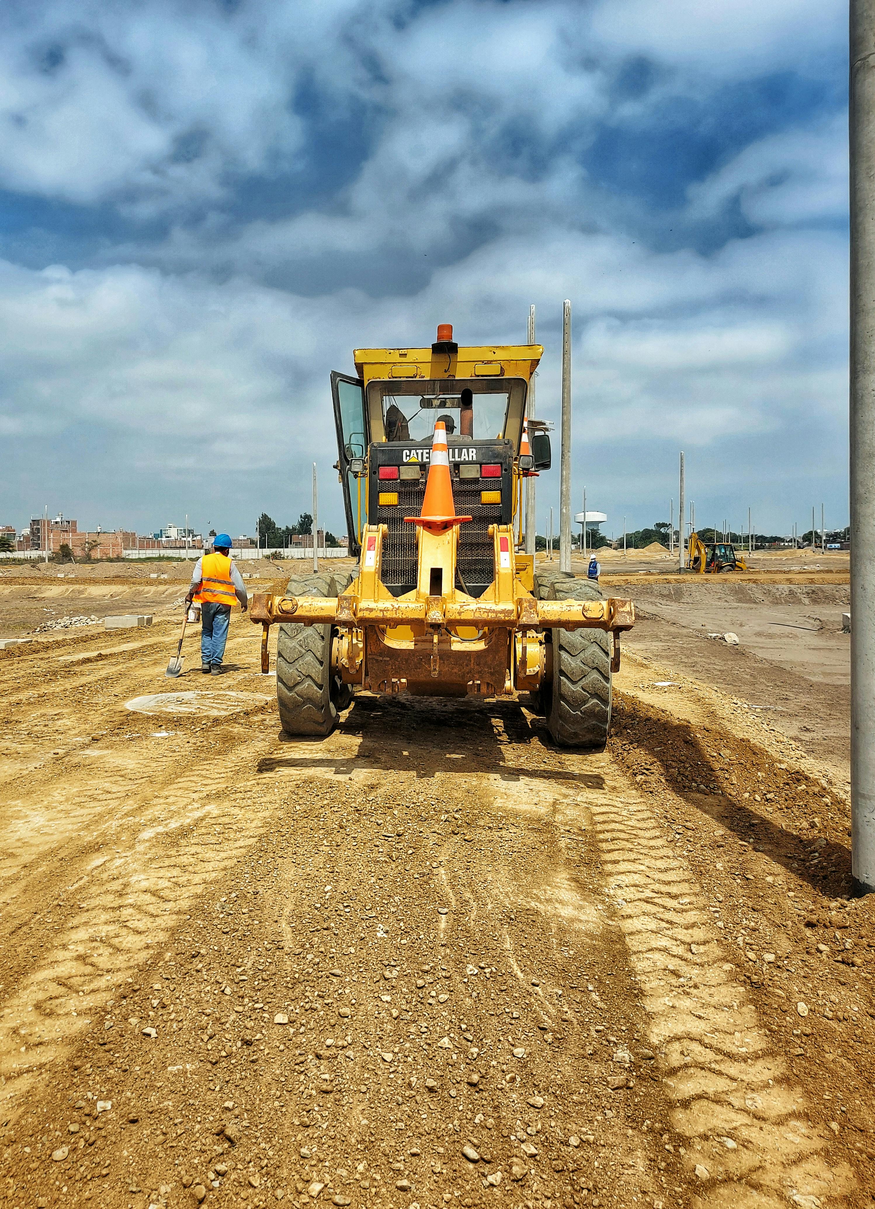 yellow heavy equipment grading a dirt road