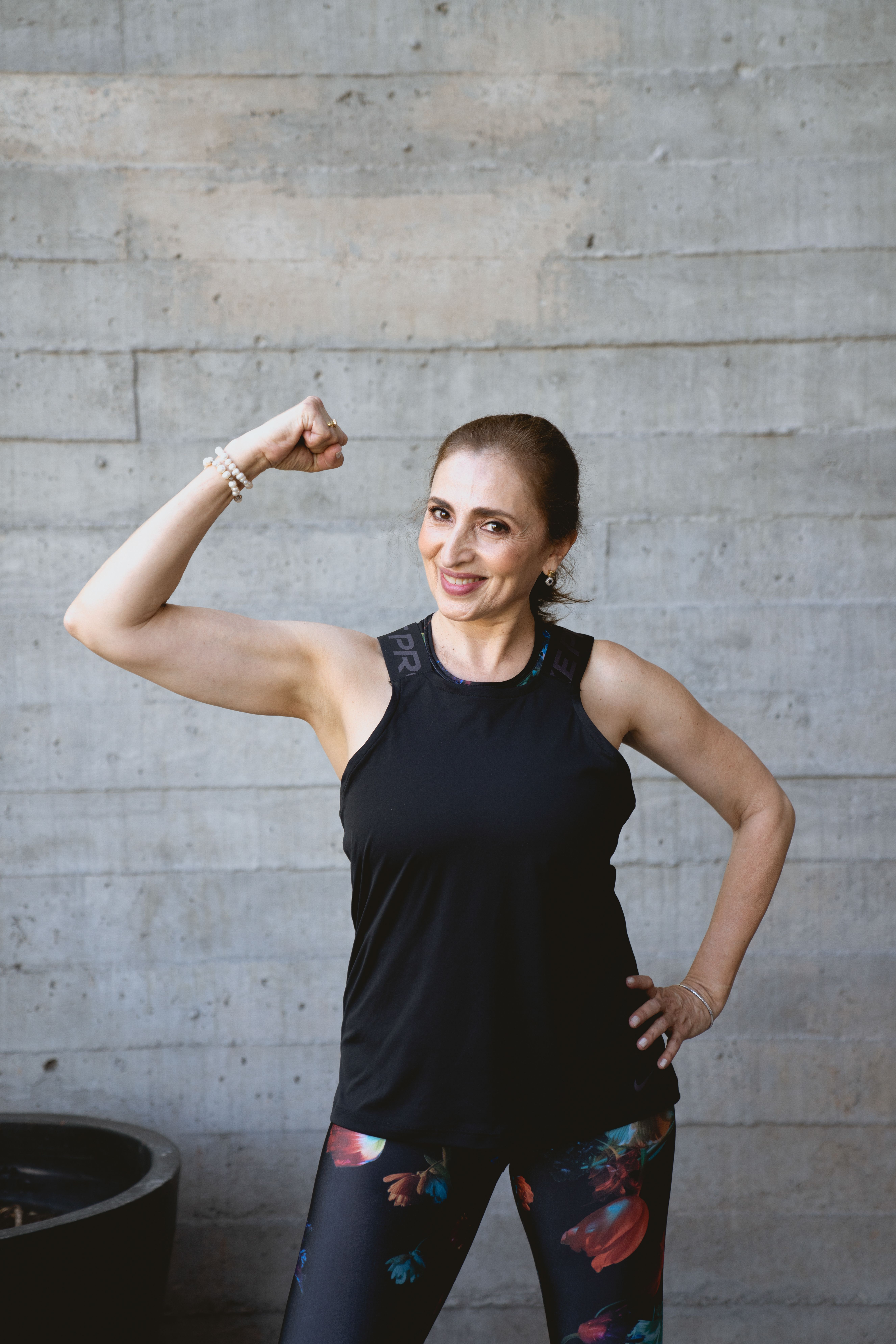 Confident senior woman flexing her arm, showcasing fitness and positive aging.