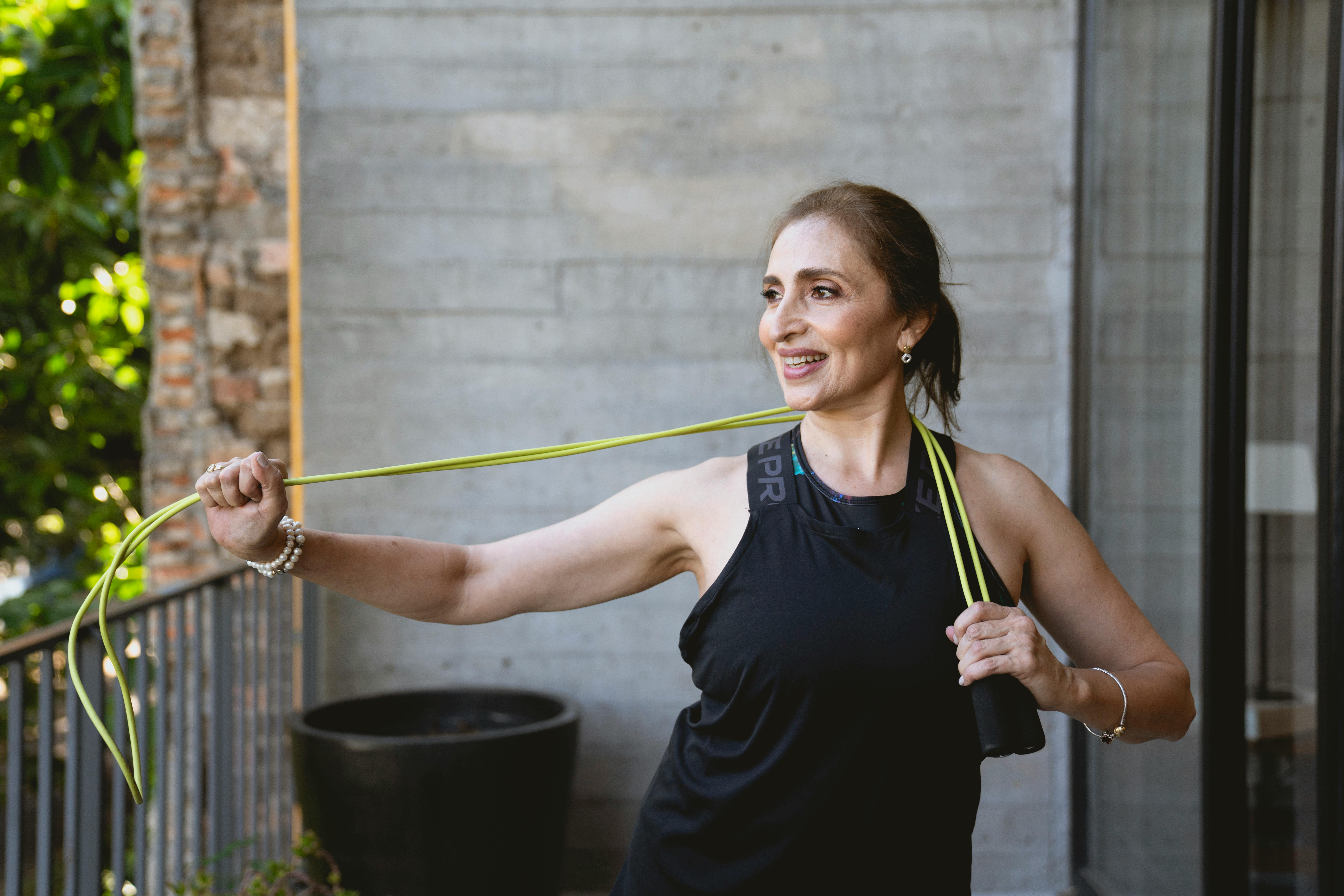 woman in black tank top holding a jumping rope