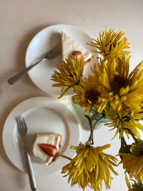Free Tantalizing cake slices paired with bright yellow flowers for a perfect dessert setting. Stock Photo
