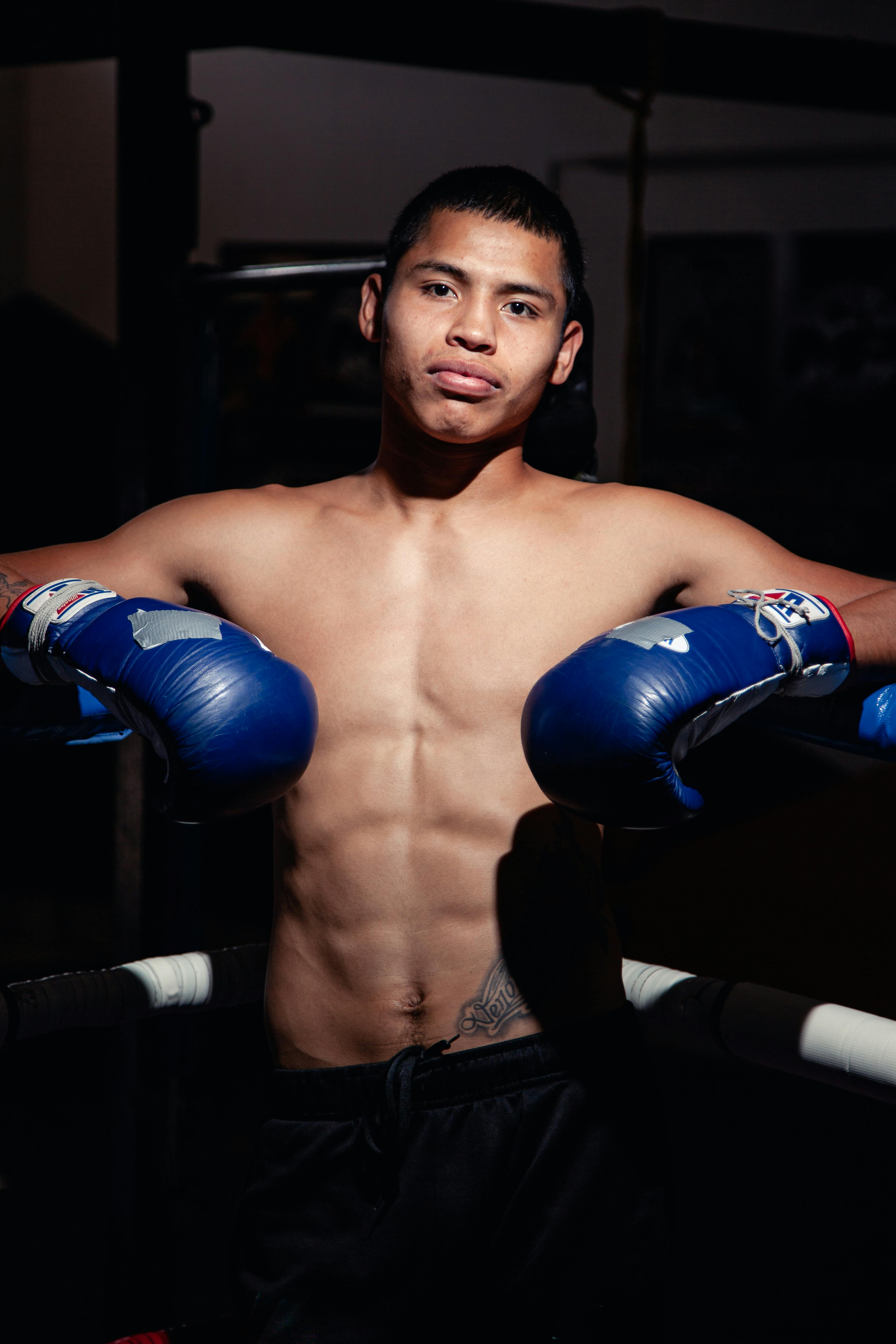 Photo of a Topless Man Wearing Blue Boxing Gloves · Free Stock Photo