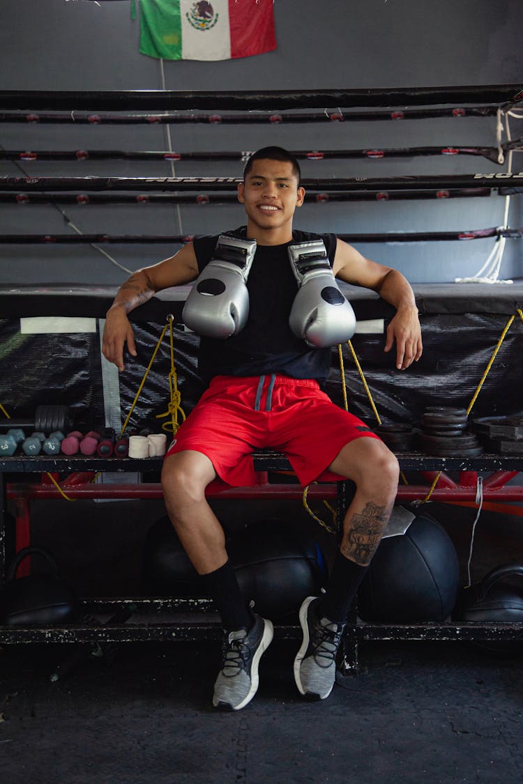 A Man In Black Tank Top Sitting Near The Boxing Ring