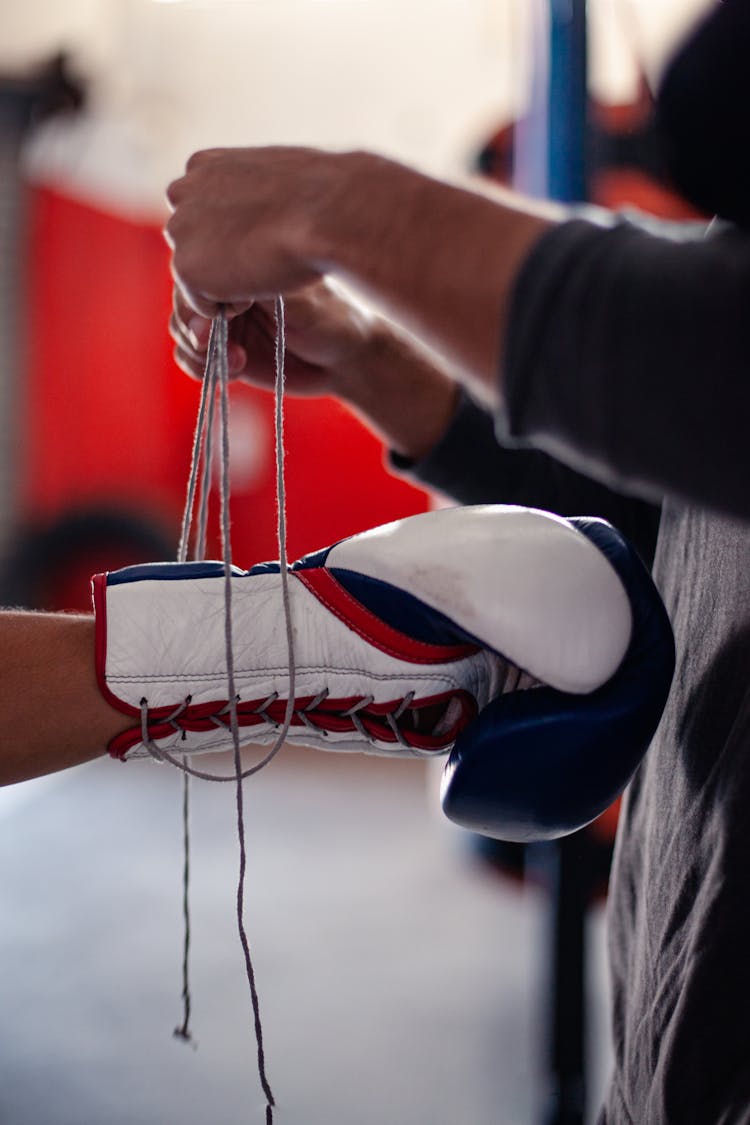 A Person Tying The Laces Of A Boxing Glove 