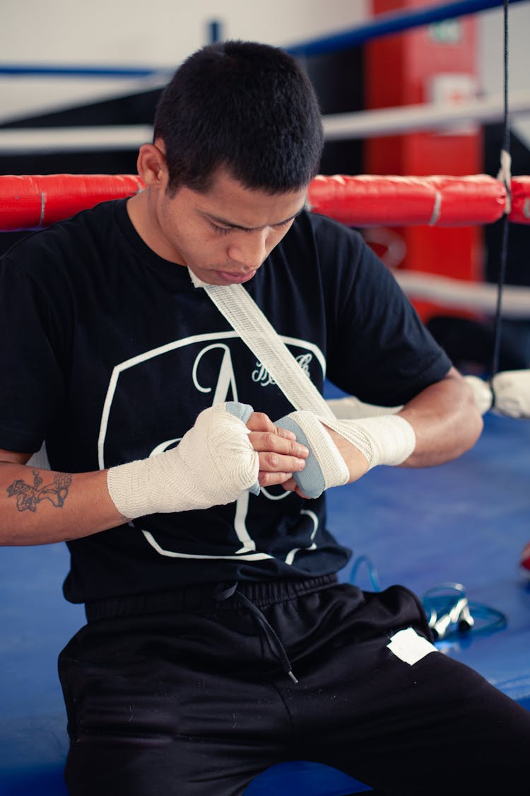 Man In Black Shirt Removing His Hand Wrap 