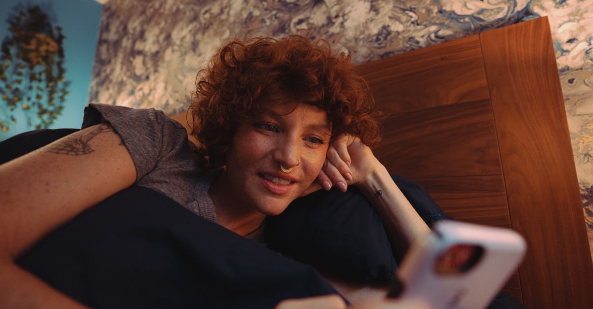 person putting phone face down on nightstand