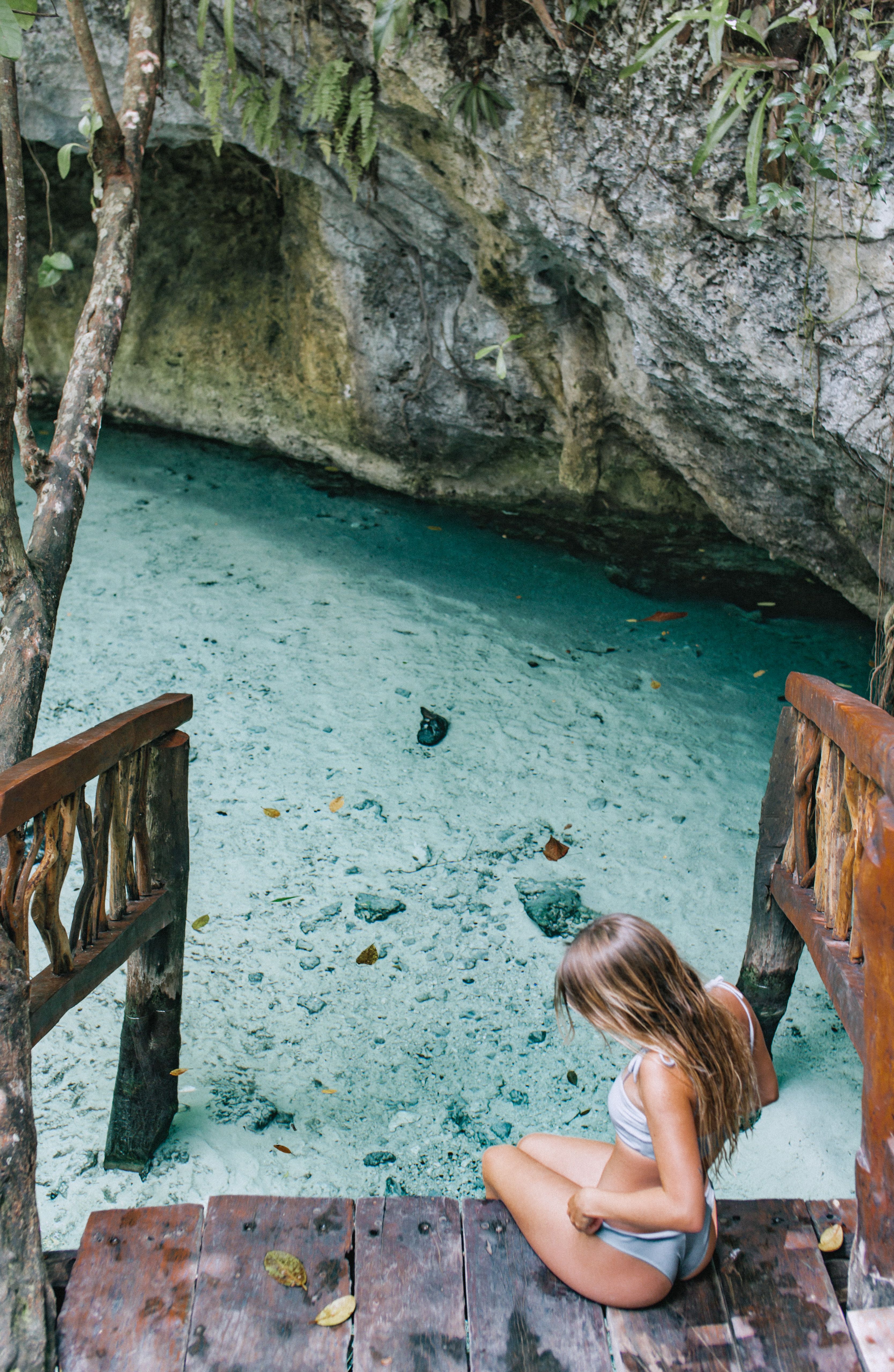 Escalier en bois descendant vers l’eau turquoise d’un cenote près de Tulum au Mexique