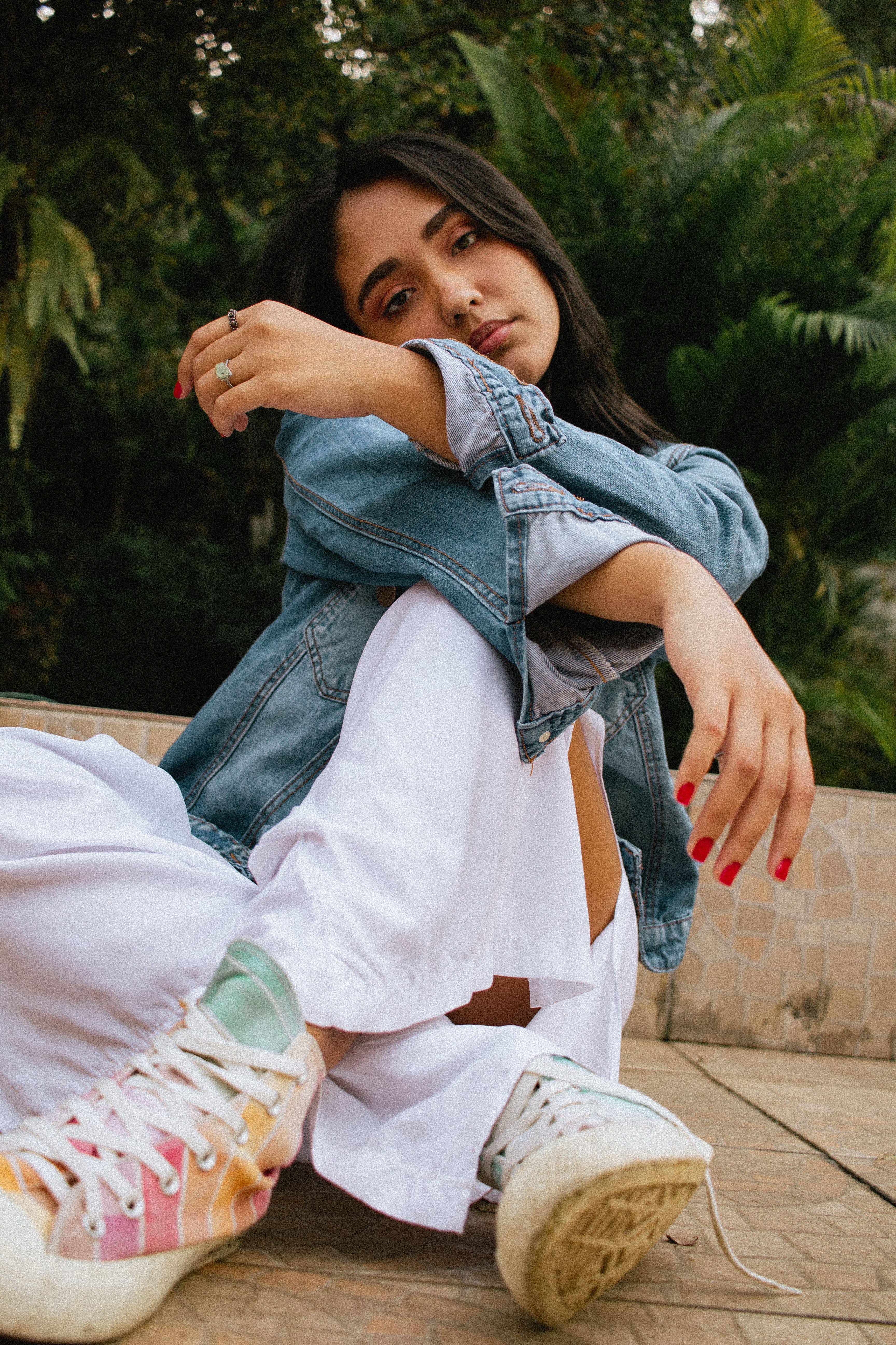Close-Up Shot of a Woman in Denim Jacket and White Pants Sitting on the ...