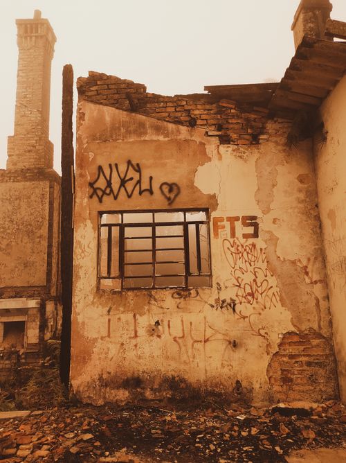 Free A decaying building exterior with graffiti and broken windows, showcasing urban decay. Stock Photo