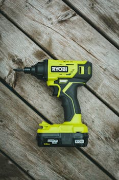 Close-up of a Ryobi cordless drill on a wooden surface, perfect for construction and DIY projects.