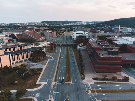 Drone shot capturing urban architecture, roads, and buildings in daylight.
