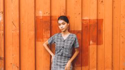 Woman standing against a painted orange wall — photo by Marc Majam on Pexels