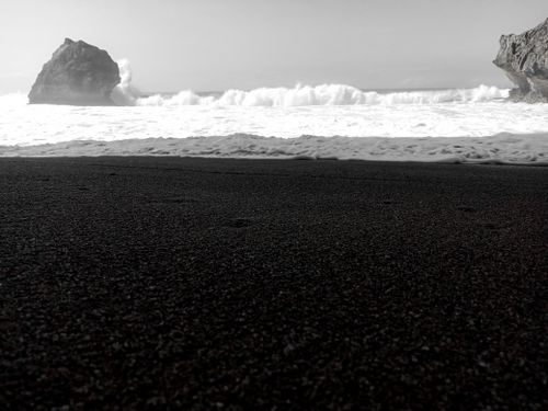 Free Black and white image of waves crashing on a rocky shoreline. Stock Photo