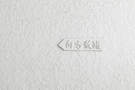 Textured white wall with carved Chinese characters, minimal design.