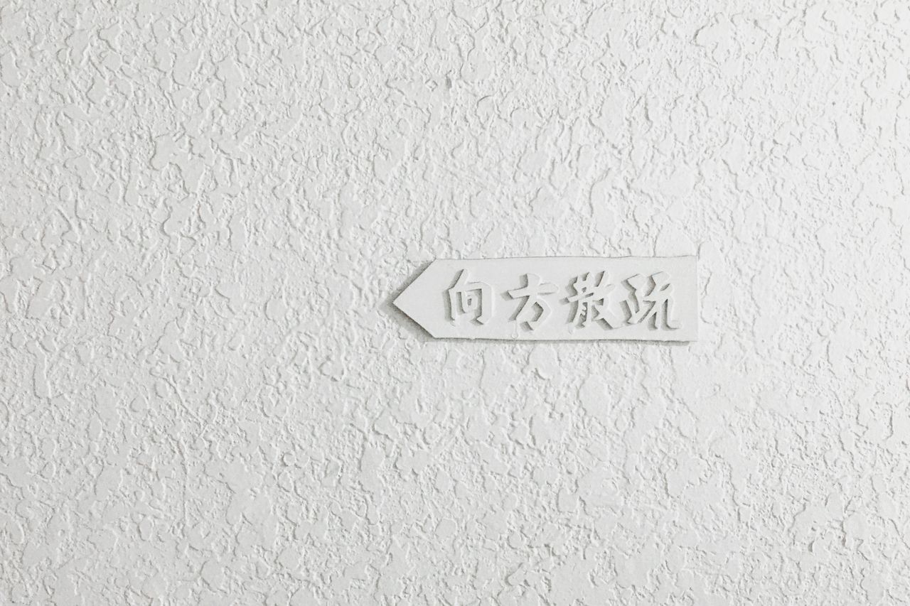 textured white wall with carved chinese characters minimal design