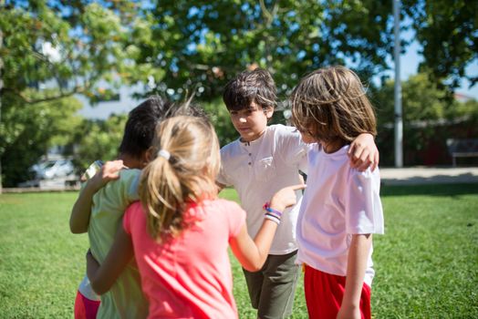 Group of children enjoying time together in a sunlit park, embracing friendship and fun.
