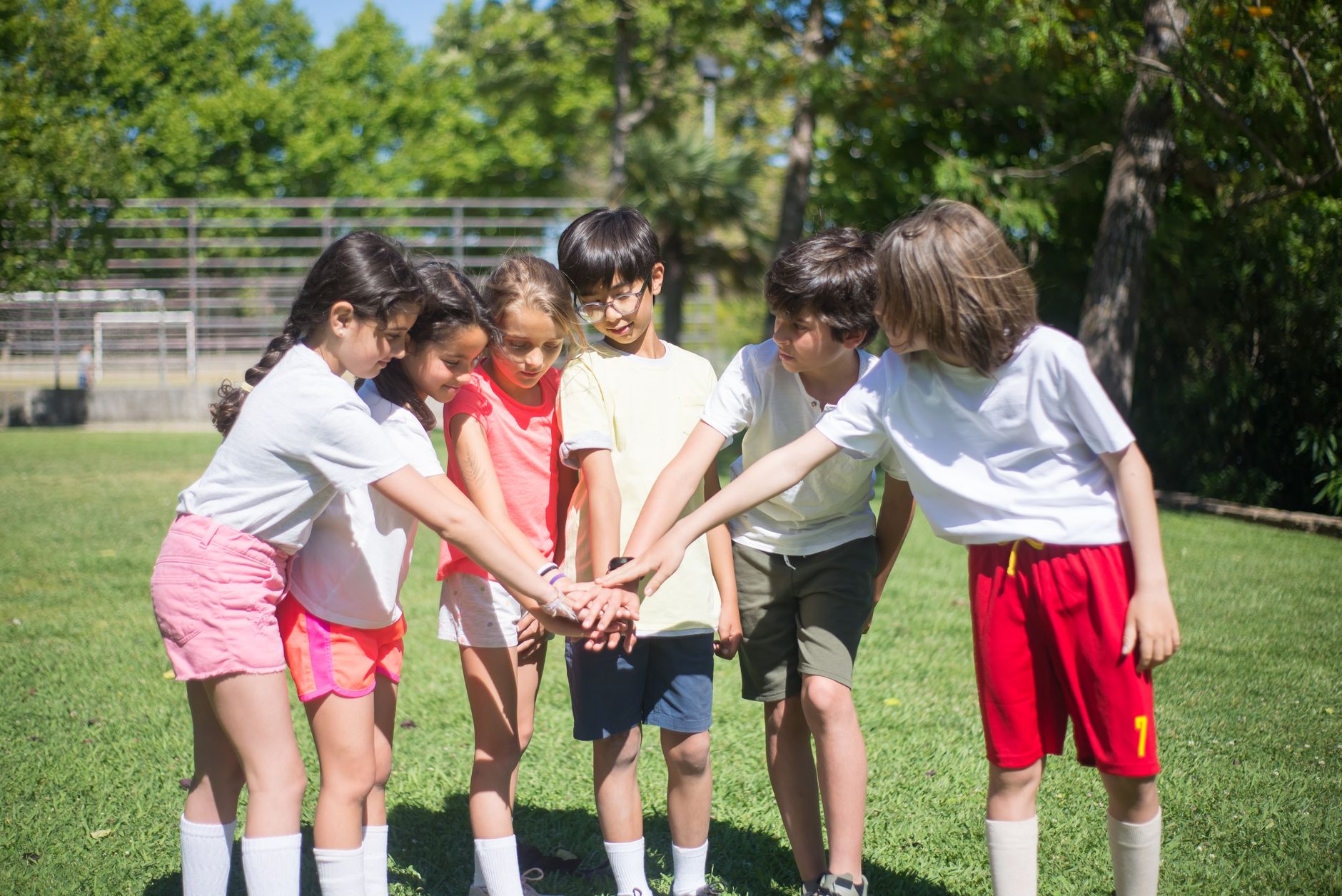 Group of kids enjoying outdoor playtime, displaying teamwork and happiness in a sunny park.