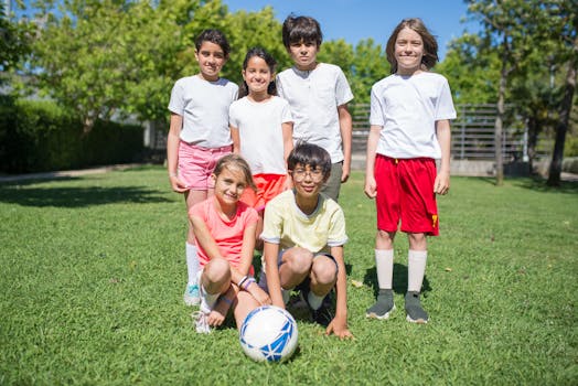 Group of kids enjoying a fun day playing soccer outdoors on a sunny day.