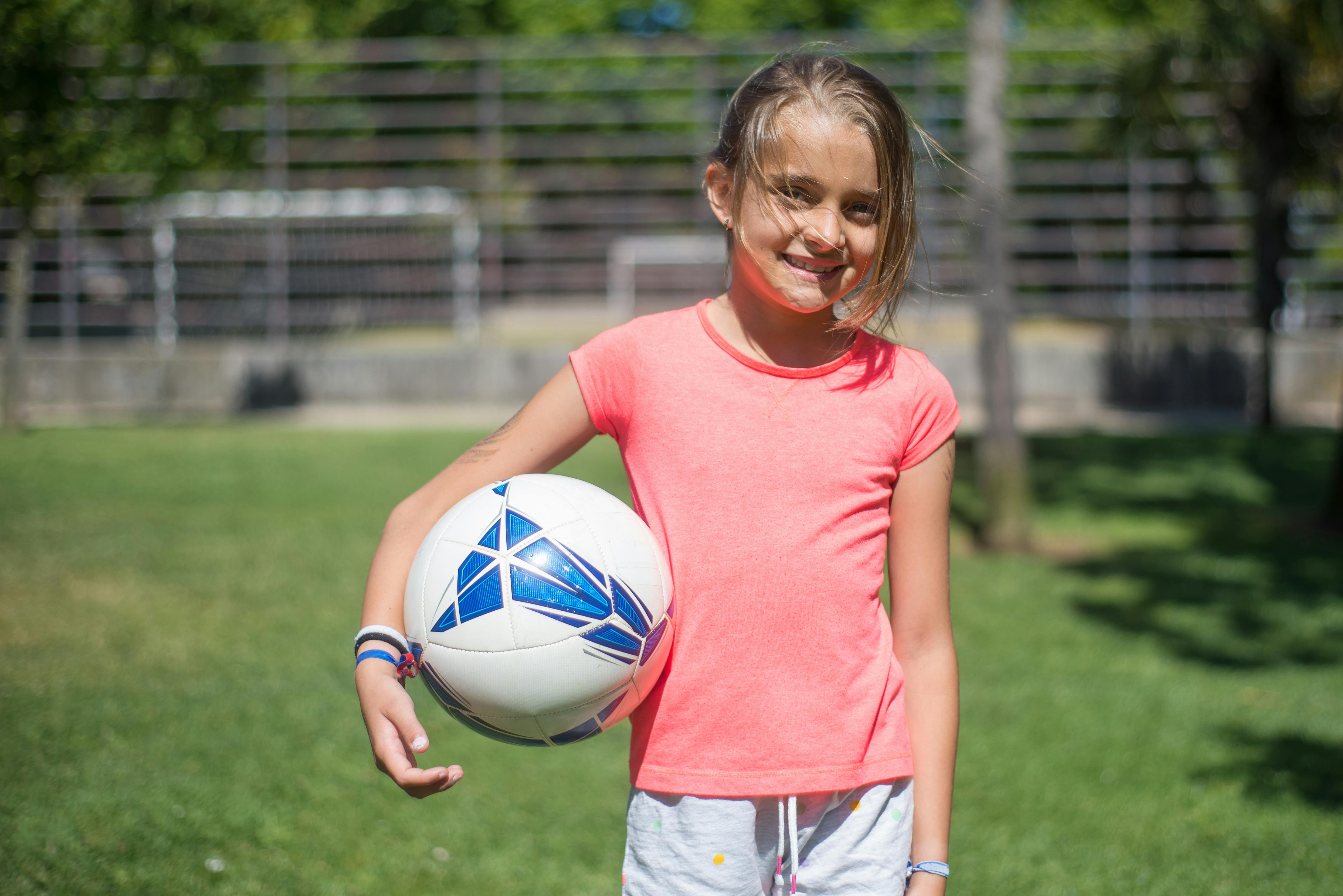 a young girl holding ball
