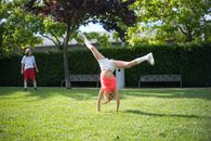 Girl tumbling on Green Grass