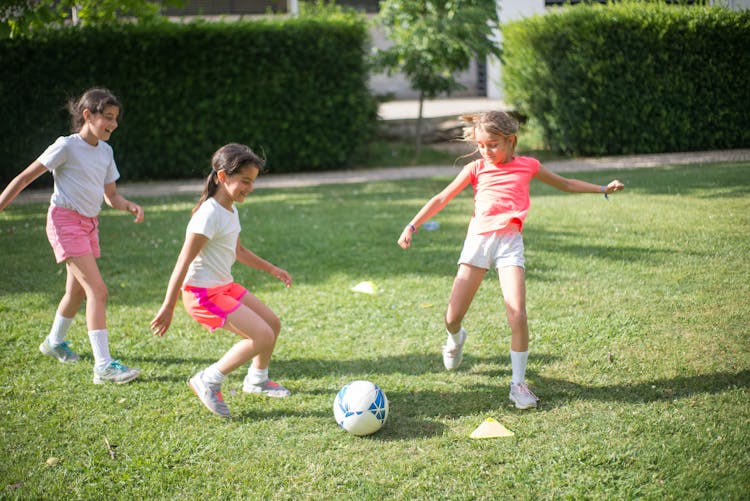 A Group Of Girls Playing Football On The Field