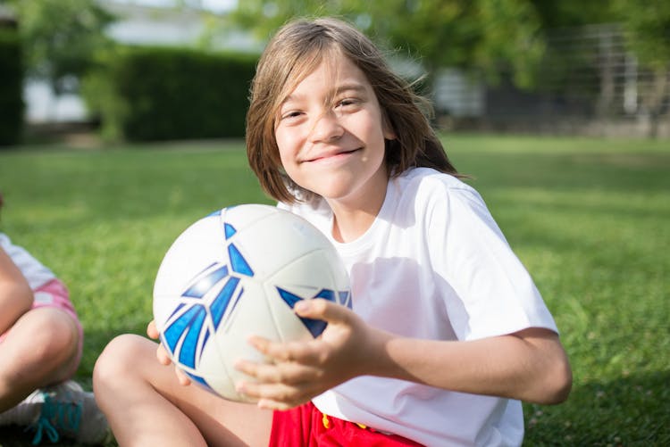 A Happy Boy Holding A Football